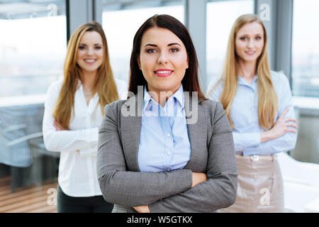 Three female business partners posing in an office Stock Photo