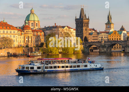 Tourist boat passing Charles Bridge and the Old Town Bridge Tower on Vltava River, Prague, Bohemia, Czech Republic, Europe Stock Photo