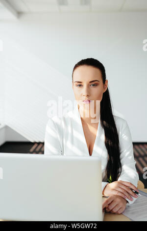 Photo of a confident female manager sitting at the desk Stock Photo