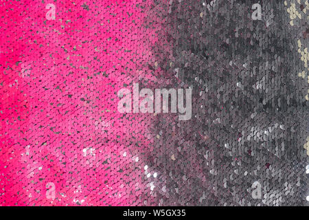 A lot of silver and pink sequins. Colorful abstract background. Gradient surface. Modern clothing material. Stock Photo