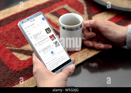 Woman with smartphone in her hands. Google search page in the the screen. Searching in the internet. Stock Photo