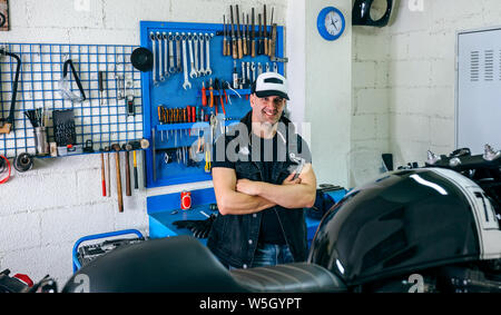 Mechanic posing with a motorcycle Stock Photo