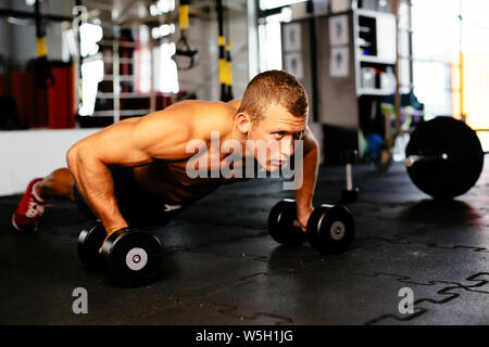 Young muscular athlete doing pushups Stock Photo