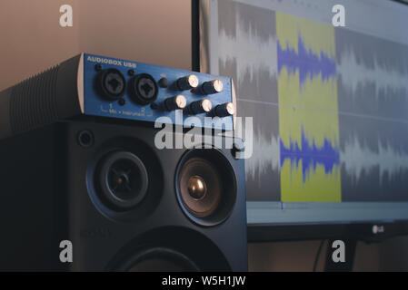 Close up of an Audiobox USB external soundboard. On the background a sound editing software can be seen on a screen. Stock Photo