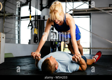 Photo of a young woman doing push-ups against her partner Stock Photo