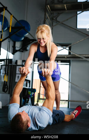 Couple trining in a gym doing pushups Stock Photo