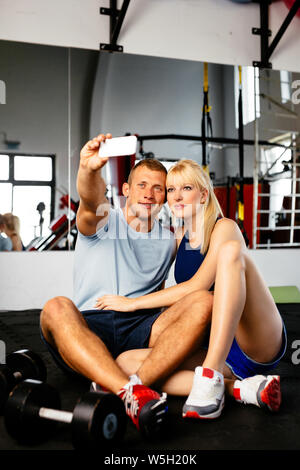 Photo of a young sporty couple taking a selfie in a fitness club Stock Photo