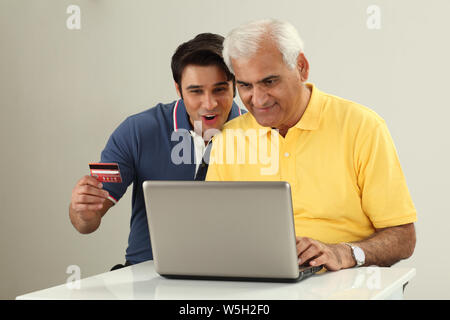 Old man with his son doing online shopping Stock Photo