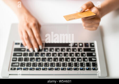 Hand of online shopper holding plastic card over keypad while paying for order Stock Photo