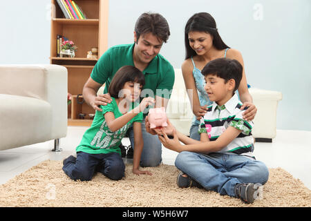 Parents assisting their children to save money Stock Photo