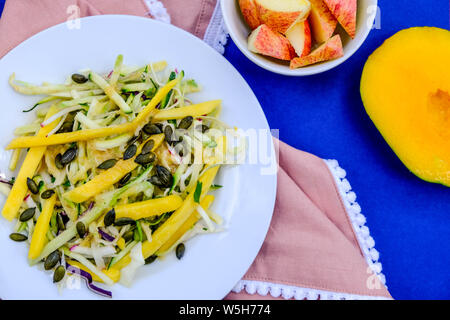 Fresh Healthy Summer Mango Fruit Salad With Apple Cabbage and Ginger Dressing Stock Photo
