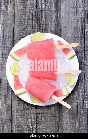 Popsicles from frozen watermelon on wooden table, top view. Stock Photo