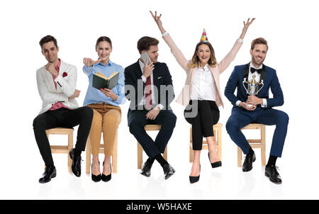 different kind of people waiting together on chairs isolated on white background Stock Photo