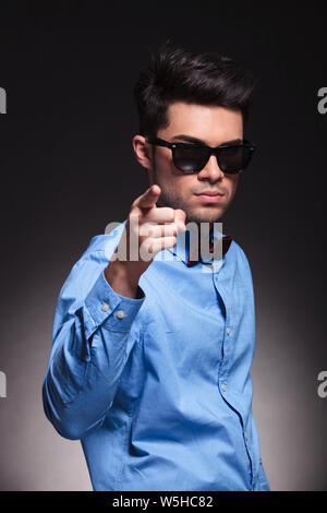 Man with sunglasses pointing forward while standing next to a medieval ...