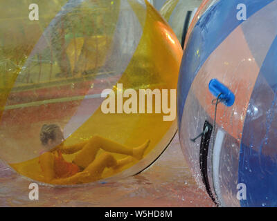 Kids having fun in inflatable bubble balls on water in amusement park, Svilajnac, Serbia, Europe Stock Photo