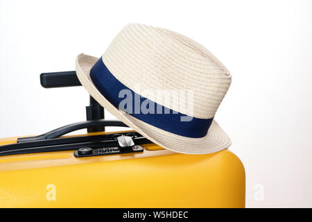 straw hat hanging on the suitcase handle. outdoor recreation concept Stock Photo