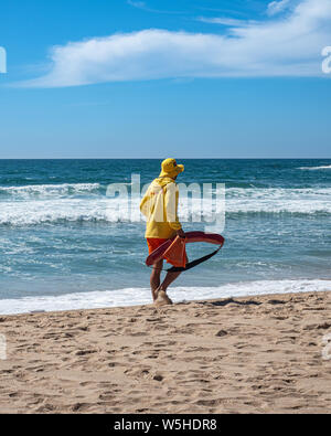 A lifeguard patrolling on the beach during summertime to protect swimmers venturing into the ocean Stock Photo