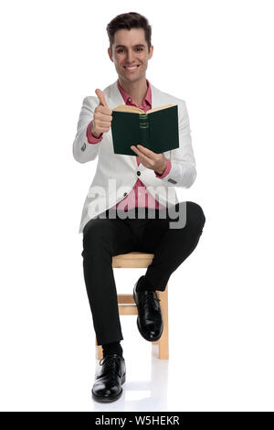 seated young elegant man makes the ok sign on white background Stock ...