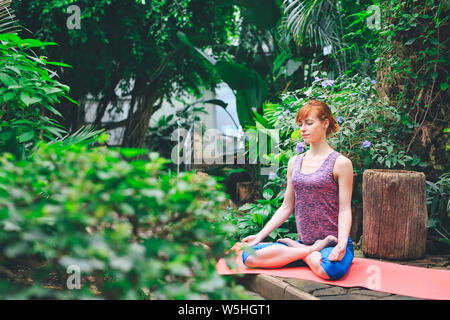 Portrait of gorgeous young woman practicing yoga indoor. Calmness and relax, female happiness. Stock Photo