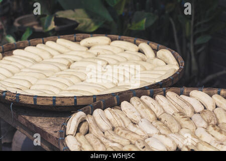Peeled bananas drying in bamboo baskets exposed to the sun in Laos Stock Photo
