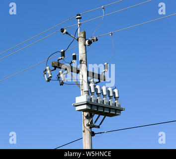 Electric transmission line connection point on pole with transformers insulators and fuses. Stock Photo