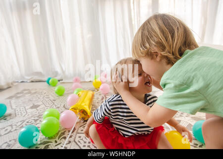 Cute toddlers playing and kissing in playroom Stock Photo