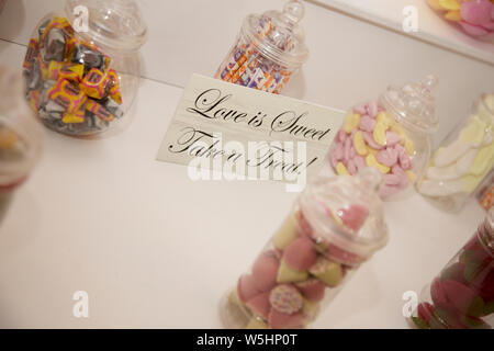 Bowls of sweets on a sweet cart at a wedding reception, waiting for the guests to come along and tuck in, no people, sweeties in jars Stock Photo