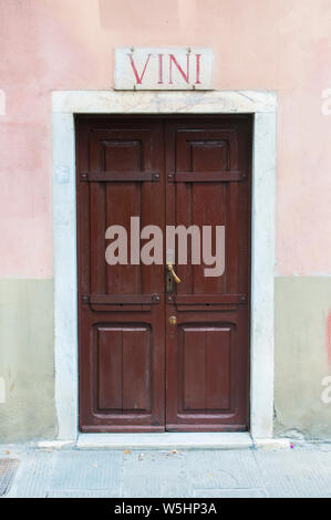 View of Carrara, Tuscany: ancient wood door of a wine shop with marble sign and the word wine Stock Photo