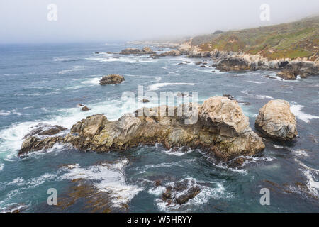 Seen from a bird's eye view, the Pacific Ocean washes against the scenic and rocky coast south of Monterey in Northern California. Stock Photo