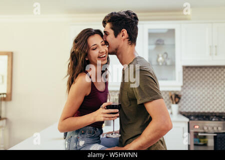 Cheerful young couple having a great time together in the kitchen. Beautiful couple in love at home. Stock Photo