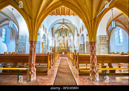 ZELL AM SEE, AUSTRIA - FEBRUARY 28, 2019: The prayer hall of St Hippolyt Church with different carved pillars, vaulted arches and golden altarpiece on Stock Photo