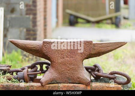 Rusty old blacksmith anvil with out of focus background Stock Photo