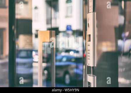 Code lock with buttons and a map on glass doors with a reflection of cars on the street on a summer day Stock Photo
