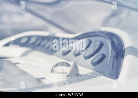 Compass with red arrow and instruments on a white yacht in high key on a sunny day Stock Photo