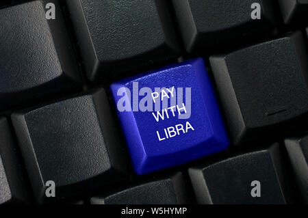 Carrara, Italy - July 29, 2019 - Concept image for online payment with the new Facebook currency Lybra. Computer keyboard with a blue key and the text Stock Photo