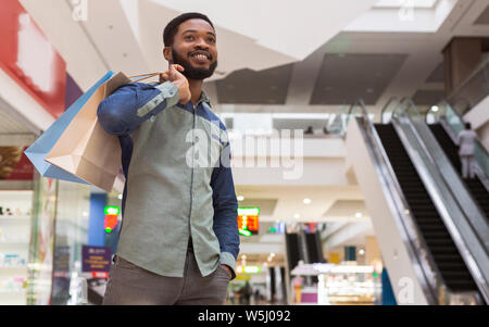 Handsome african man with purchases waiting for girlfriend Stock Photo