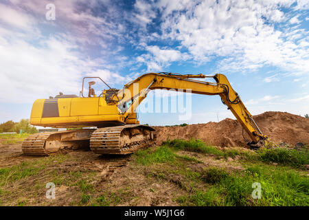 industrial excavator working on construction site digging a pit Stock Photo