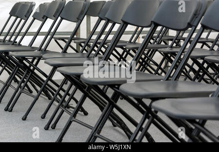 numerous folding chairs arranged in a row in a conference room. Stock Photo