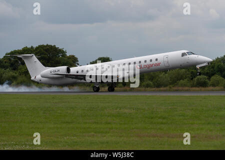 A Loganair Embraer 145 lands at Manchester International Airport (Editorial use only) Stock Photo