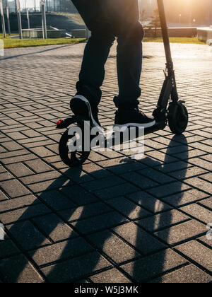 Close up view of legs of man on electric scooter outdoor. Stock Photo