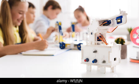 Children studying in class with robot at foreground Stock Photo