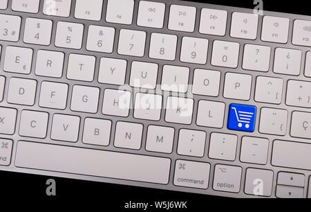 Computer notebook keyboard with icon shopping cart on key. E-commerce concept Stock Photo