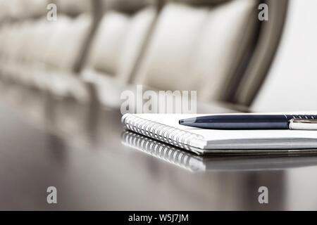 Closeup of notepad kept on table in empty room Stock Photo