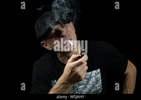 A handsome young man with a cigarette in the cloud of smoke Stock Photo