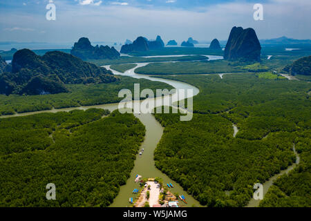 Aerial drone view of a small pier with traditional wooden Longtail boats leading into mangrove forest (Phang Nga Bay) Stock Photo