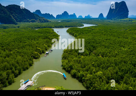 Aerial drone view of a small pier with traditional wooden Longtail boats leading into mangrove forest (Phang Nga Bay) Stock Photo
