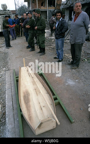 25th April 1993 During the war in Bosnia: in Stari Vitez, ARBiH (Bosnian Muslim) soldiers and a few local people watch as a body is prepared for burial after being pulled from the ruins of the Bosnian War Presidency. Stock Photo