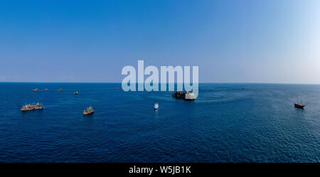 Panoramic aerial view of a large fleet of fishing trawlers and a single SCUBA diving boat around a famous dive site in the Mergio Archipelago, Myanmar Stock Photo