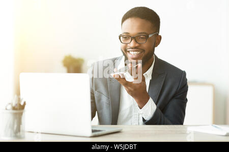African Man Using Voice Assistant On Cellphone Stock Photo
