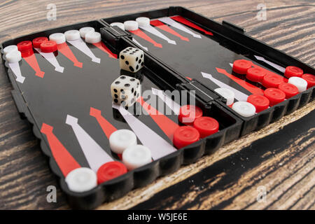Small pocket backgammon on a wooden table. Stock Photo